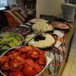 A buffet table with assorted fresh vegetables and toppings.