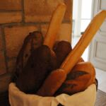 Basket with fresh baguettes near a door.