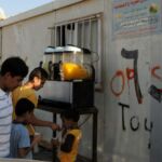 Family enjoying fresh juice from a street vendor at a small stand.