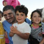 Syrian refugee volunteer with children Syrian refugee volunteer with children