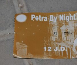 A weathered sign reading 'Petra By Night!' with a time and date.