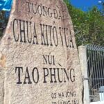 Stone monument with inscriptions in Vietnamese under a blue sky.