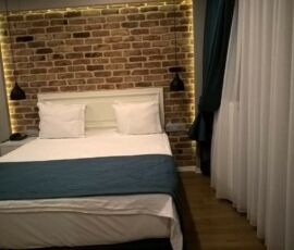 Cozy bedroom with exposed brick wall and soft lighting.