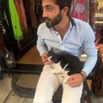 Man sitting indoors with a black dog on his lap.