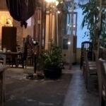 Cozy outdoor restaurant seating with warm lighting in the evening.