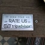 A wooden sign asking customers to rate the place on TripAdvisor.